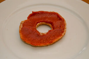 Bagel covered in pizza sauce